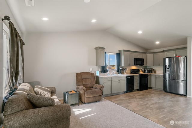 kitchen with light wood-type flooring, black appliances, lofted ceiling, and gray cabinetry