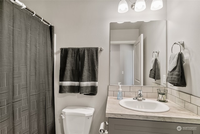 bathroom featuring vanity, backsplash, and toilet