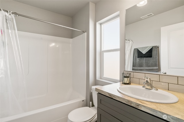 full bathroom with backsplash, vanity, toilet, and shower / bath combo with shower curtain