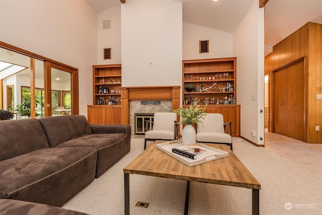 living room with light carpet, high vaulted ceiling, a premium fireplace, and visible vents