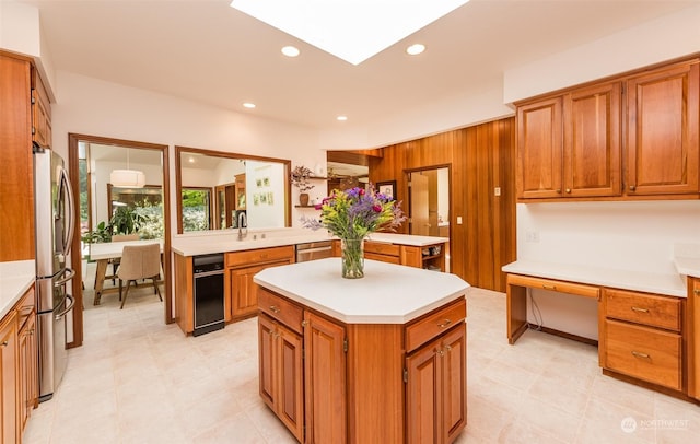 kitchen featuring a center island, brown cabinets, light countertops, and stainless steel appliances