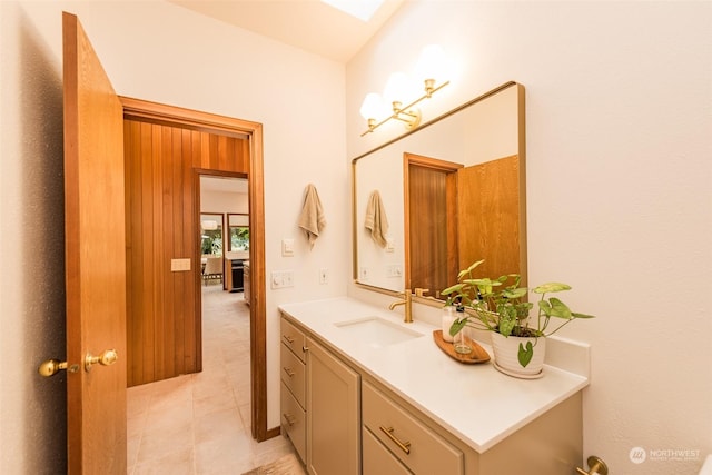 bathroom with tile patterned floors, a skylight, and vanity