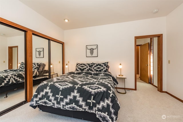 carpeted bedroom featuring baseboards and a closet