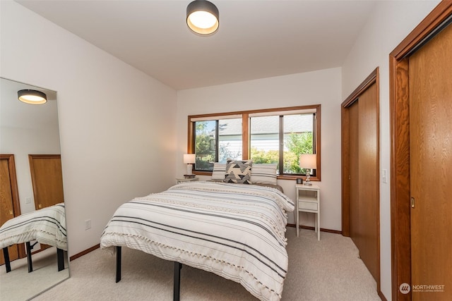 bedroom featuring baseboards and light carpet