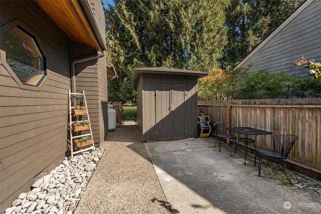 view of patio / terrace featuring an outbuilding, a shed, and fence