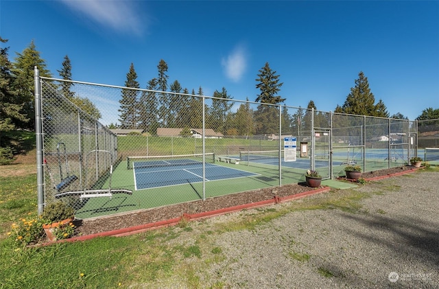 view of tennis court featuring fence