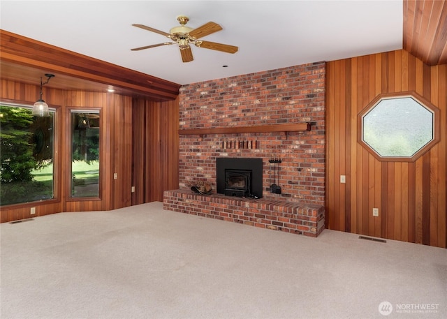 125 Arnold Palmer Pkwy, Sequim, WA 98382 - unfurnished living room featuring wooden walls, carpet floors, a wood stove, and ceiling fan