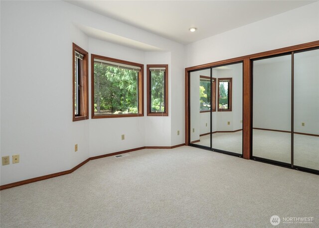 125 Arnold Palmer Pkwy, Sequim, WA 98382 - unfurnished bedroom with multiple windows, multiple closets, and carpet floors