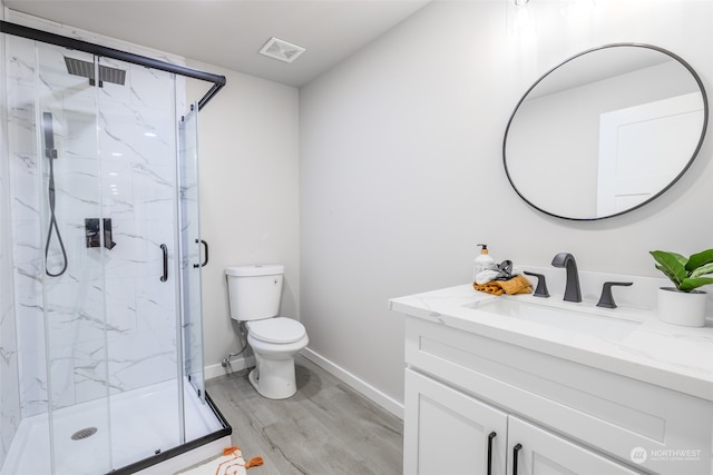 bathroom with walk in shower, vanity, hardwood / wood-style floors, and toilet