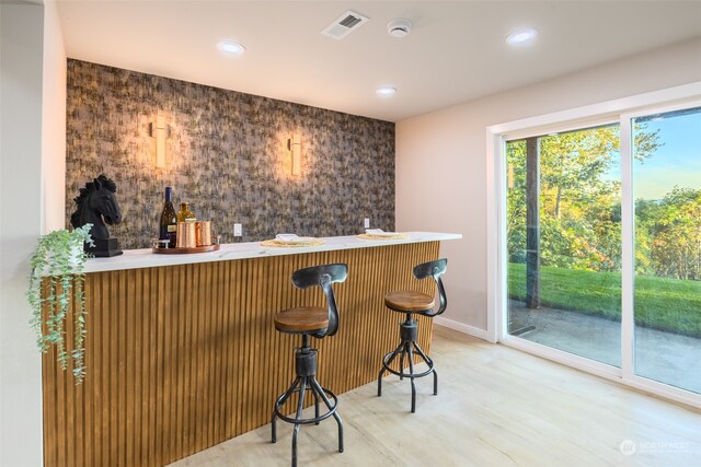 bar with hardwood / wood-style floors