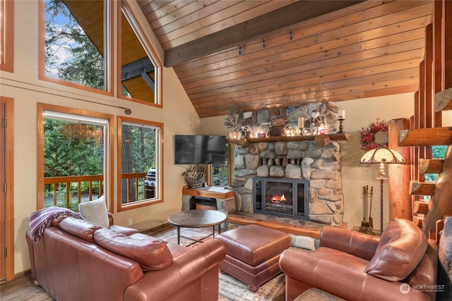 living room featuring wood ceiling, plenty of natural light, a stone fireplace, and beamed ceiling