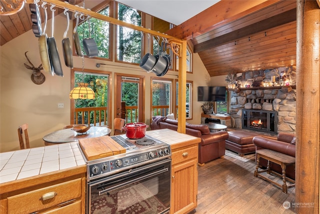 kitchen with tile counters, a fireplace, high vaulted ceiling, electric range, and beam ceiling