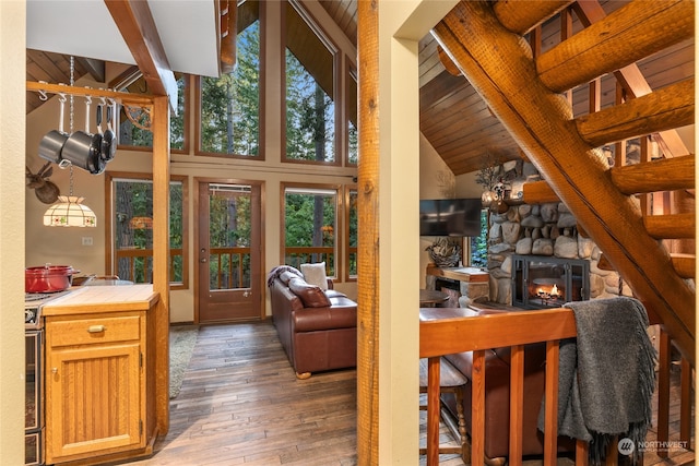 living room with wooden ceiling, dark wood-type flooring, a fireplace, high vaulted ceiling, and beam ceiling