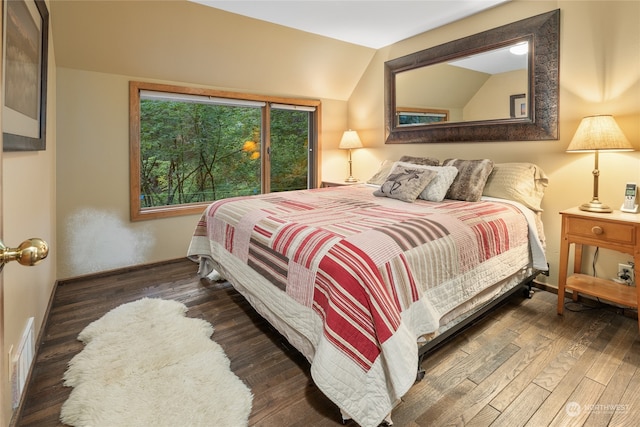 bedroom with dark hardwood / wood-style flooring and lofted ceiling