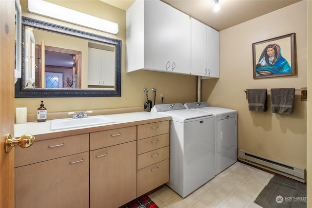 laundry area featuring a sink, baseboard heating, washing machine and dryer, and cabinet space