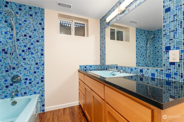 full bath with tub / shower combination, backsplash, visible vents, and wood finished floors