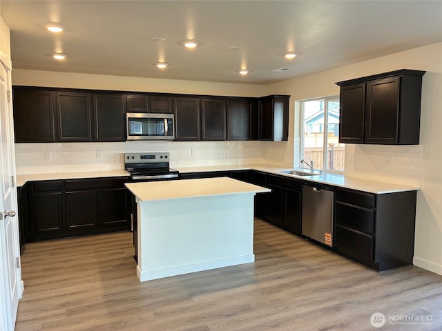 12707 172nd Avenue Ct E Unit 135, Bonney Lake, WA 98391 - kitchen featuring stainless steel appliances, a sink, light wood-style flooring, tasteful backsplash, and recessed lighting