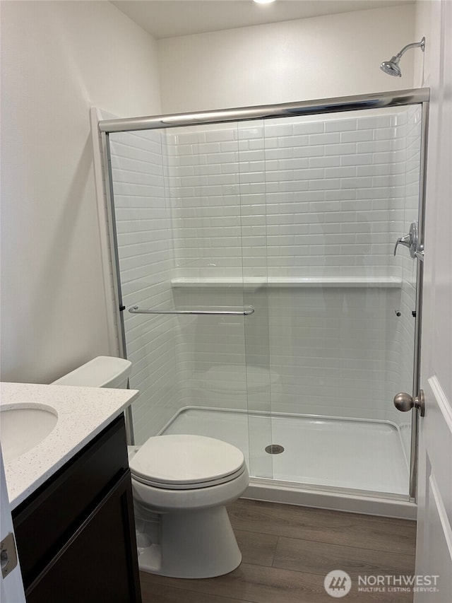 12707 172nd Avenue Ct E Unit 135, Bonney Lake, WA 98391 - bathroom featuring wood finished floors, vanity, a stall shower, and toilet