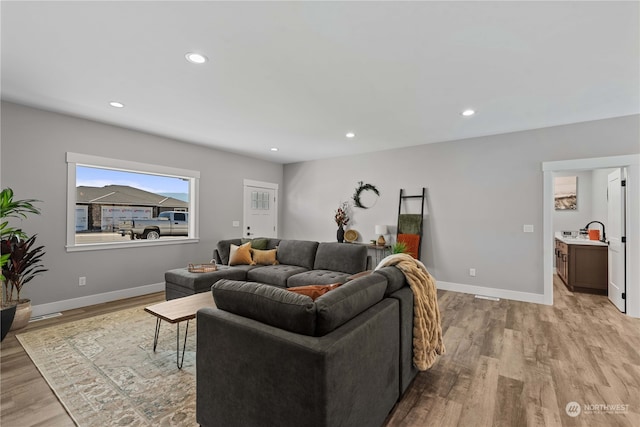 living room featuring light wood-type flooring and sink