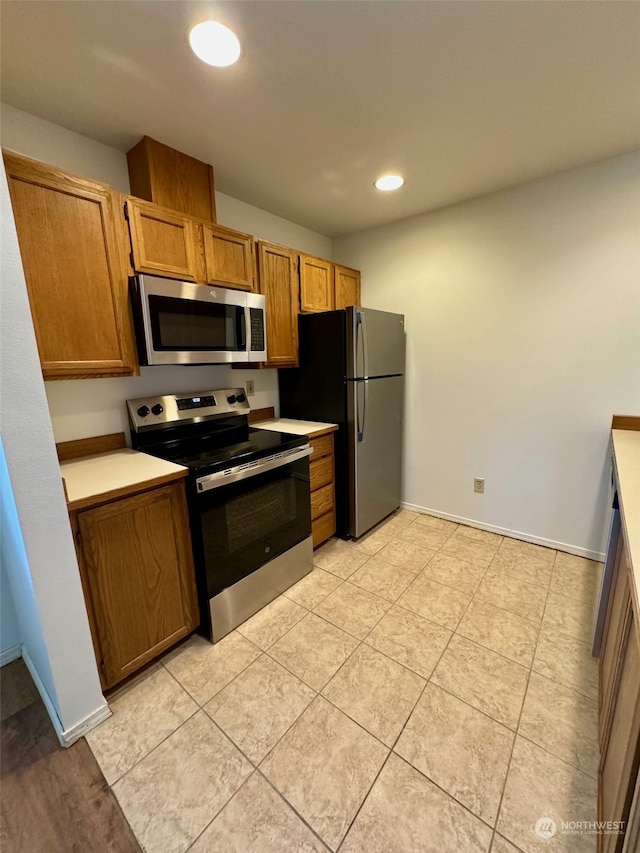 kitchen featuring stainless steel appliances and light tile patterned flooring