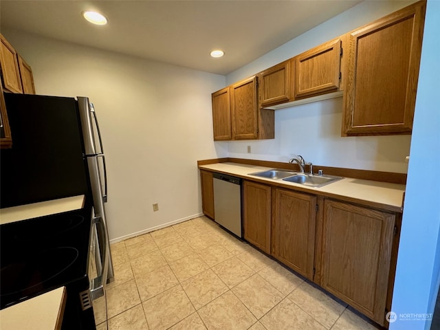 kitchen featuring light tile patterned floors, dishwasher, stove, and sink