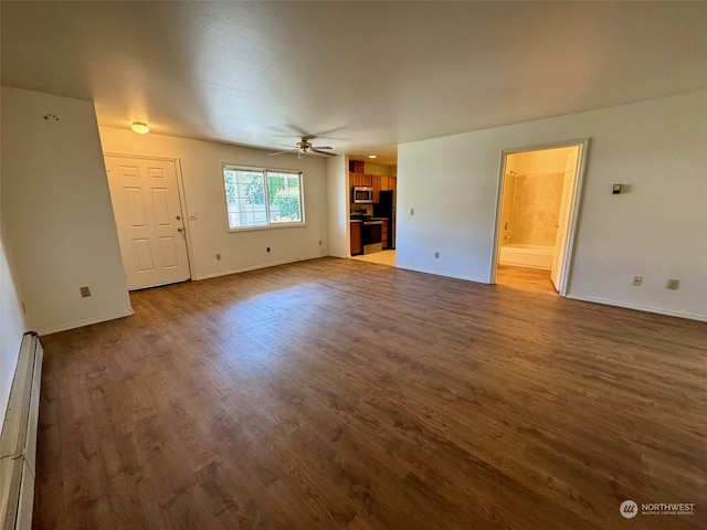 unfurnished living room featuring wood-type flooring, baseboard heating, and ceiling fan