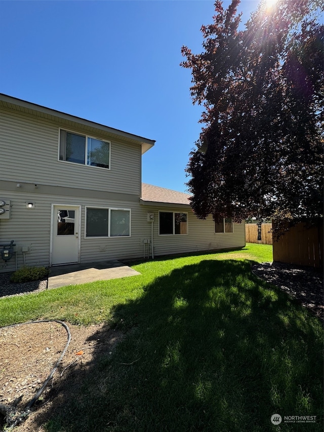 rear view of house featuring a lawn and a patio area