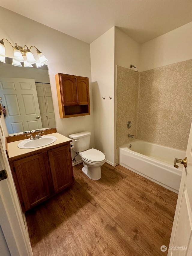 full bathroom with wood-type flooring, vanity, shower / bath combination, and toilet