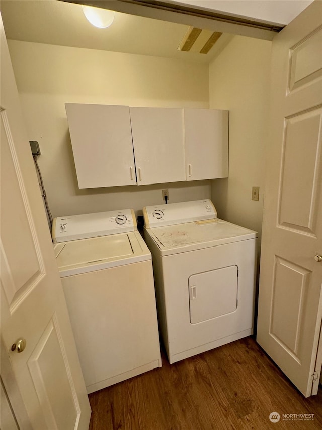 washroom with cabinets, dark hardwood / wood-style flooring, and washing machine and dryer