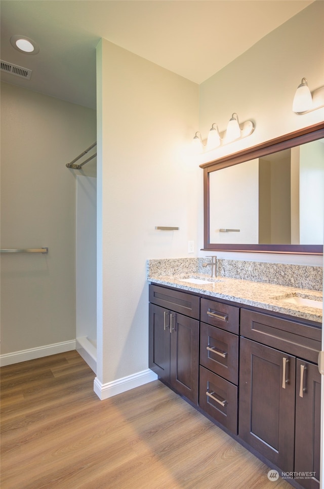 bathroom featuring vanity, walk in shower, and hardwood / wood-style floors