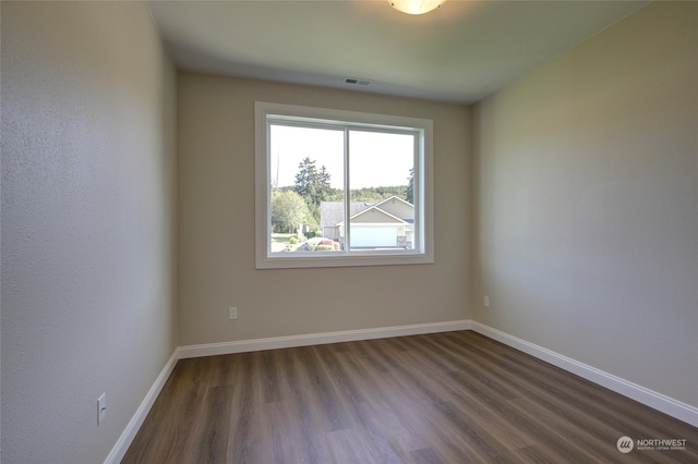 empty room with dark hardwood / wood-style flooring