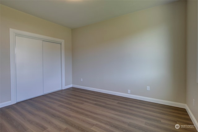 unfurnished bedroom featuring a closet and dark hardwood / wood-style floors