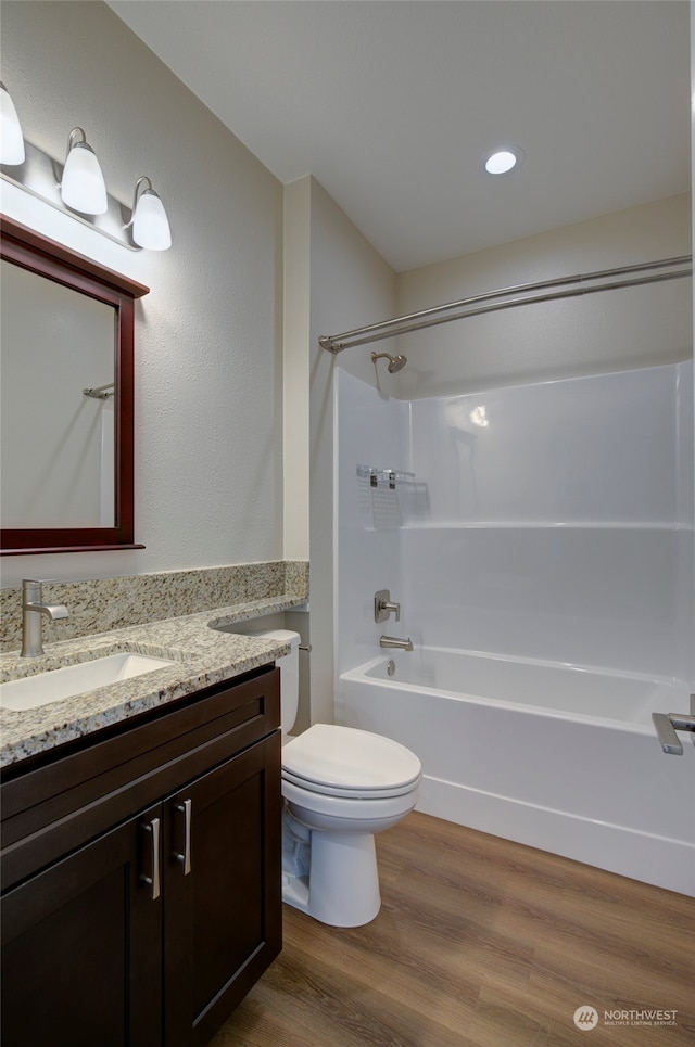 full bathroom featuring washtub / shower combination, vanity, toilet, and hardwood / wood-style flooring