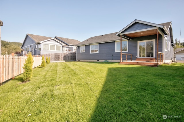 rear view of property featuring a deck and a yard