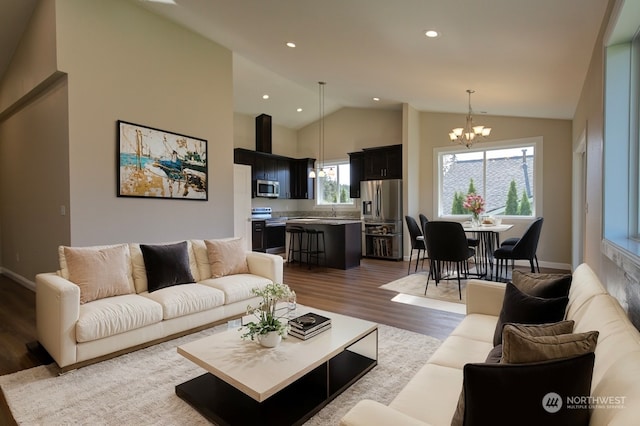 living room with sink, dark hardwood / wood-style floors, a chandelier, and high vaulted ceiling