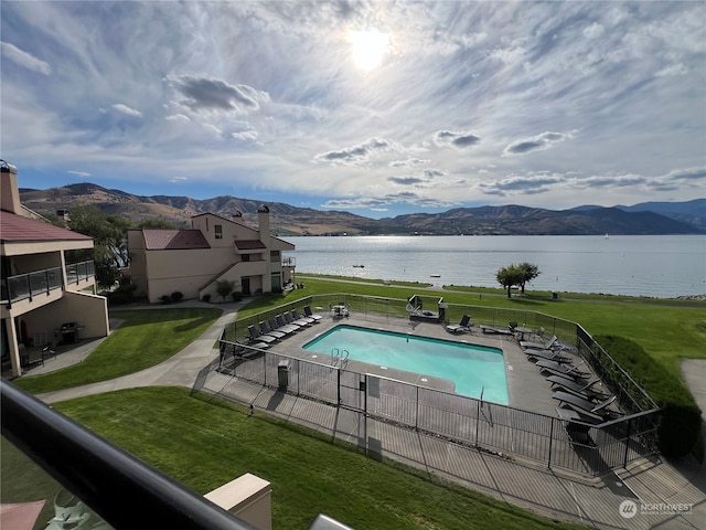 view of swimming pool featuring a water and mountain view, a yard, and a patio area