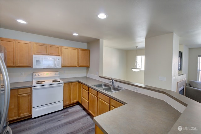 kitchen with sink, kitchen peninsula, white appliances, hardwood / wood-style floors, and decorative light fixtures