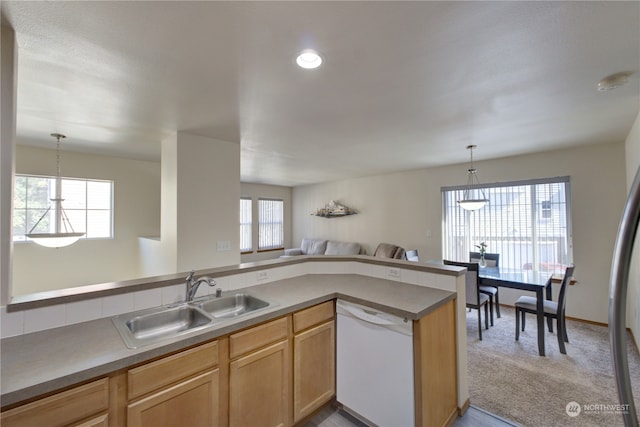 kitchen with light carpet, white dishwasher, sink, and a healthy amount of sunlight