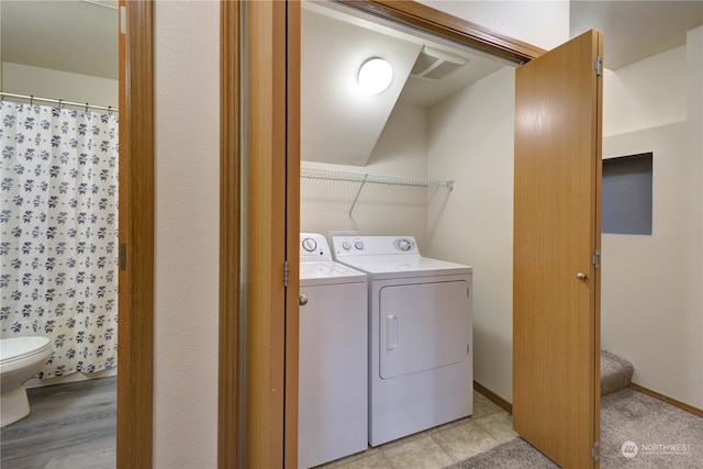 laundry room featuring light hardwood / wood-style floors and washing machine and dryer