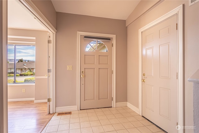 foyer with lofted ceiling and light wood-type flooring