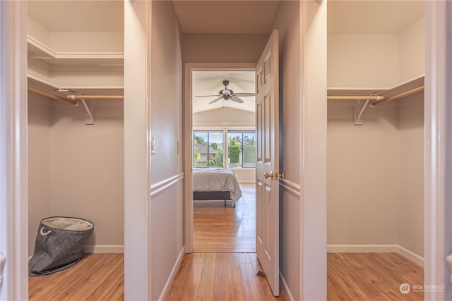 spacious closet featuring ceiling fan, vaulted ceiling, and light wood-type flooring