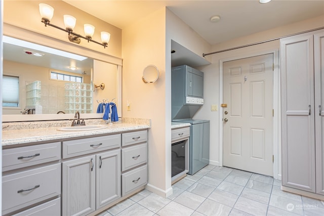 bathroom featuring vanity, stacked washer / dryer, and tile patterned floors