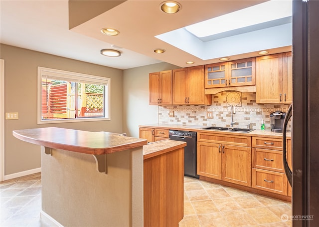 kitchen with a kitchen island, a breakfast bar area, sink, black appliances, and tasteful backsplash