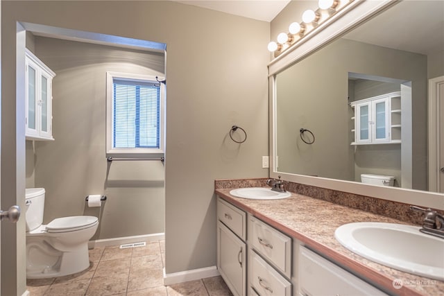 bathroom with vanity, toilet, and tile patterned floors