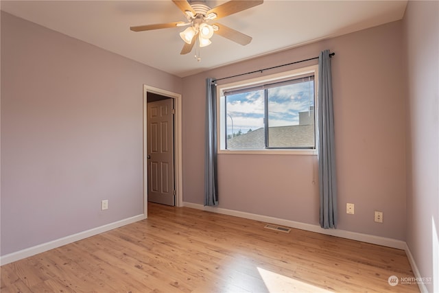 spare room with light wood-type flooring and ceiling fan