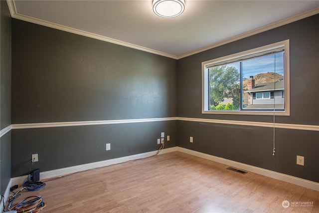 unfurnished room featuring crown molding and wood-type flooring