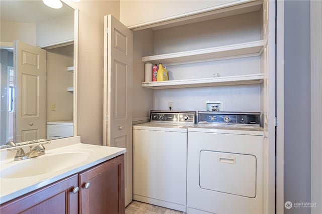 clothes washing area with independent washer and dryer and sink