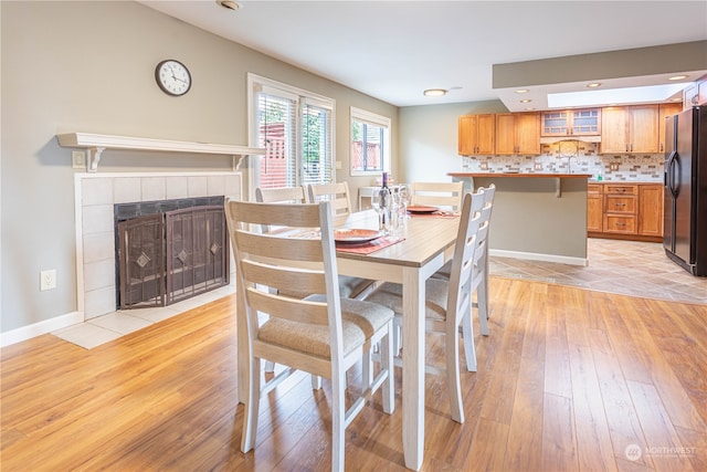 dining area with light hardwood / wood-style floors and a fireplace