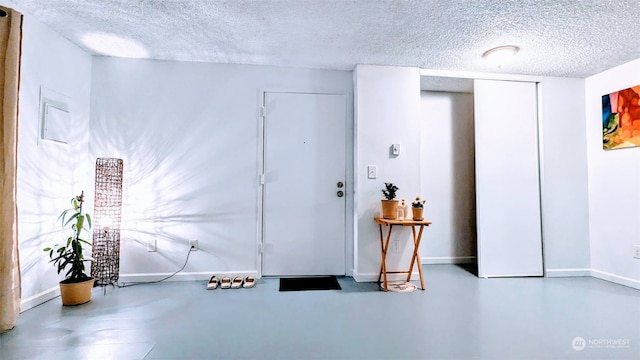 foyer entrance featuring concrete flooring and a textured ceiling