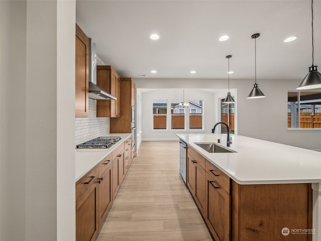 kitchen with light hardwood / wood-style flooring, stainless steel appliances, a large island, sink, and pendant lighting